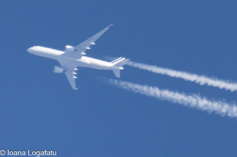 Jet gliding through a clear blue sky above
